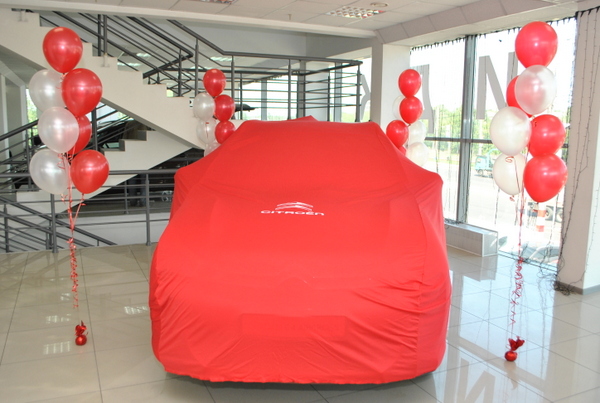 Машина «Citroen» под красным покрывалом 